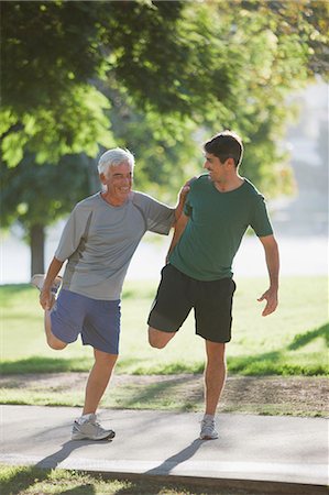 Older man stretching with trainer Stock Photo - Premium Royalty-Free, Code: 6113-06499051