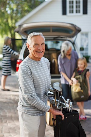 simsearch:6113-06499012,k - Older man carrying golf clubs in bag Stock Photo - Premium Royalty-Free, Code: 6113-06499018