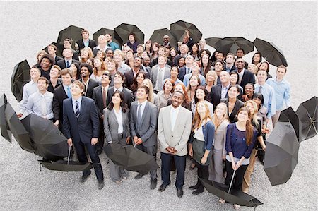 simsearch:6113-06499214,k - Portrait of smiling business people with umbrellas looking up Stock Photo - Premium Royalty-Free, Code: 6113-06499160