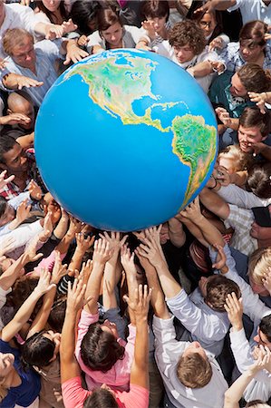 Crowd of people reaching for globe Stock Photo - Premium Royalty-Free, Code: 6113-06499192