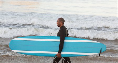 picture of a middle aged man on a surf board - Older surfer carrying board on beach Stock Photo - Premium Royalty-Free, Code: 6113-06499110