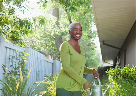 simsearch:6113-06499128,k - Older woman watering plants in backyard Fotografie stock - Premium Royalty-Free, Codice: 6113-06499123