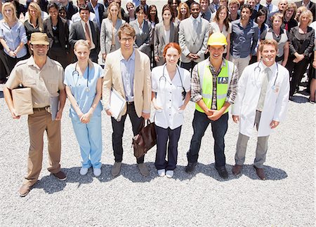 protection teamwork copy space - Portrait of smiling professionals and workers with business people in background Stock Photo - Premium Royalty-Free, Code: 6113-06499206