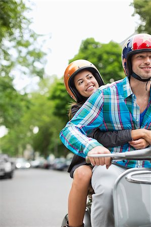 Couple riding scooter together Stock Photo - Premium Royalty-Free, Code: 6113-06625573