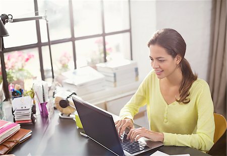 Woman using laptop at desk Foto de stock - Sin royalties Premium, Código: 6113-06625591