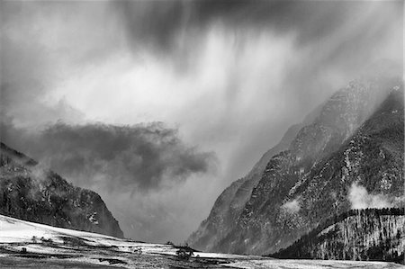 simsearch:6113-06626677,k - Clouds over snowy rural landscape Photographie de stock - Premium Libres de Droits, Code: 6113-06625512