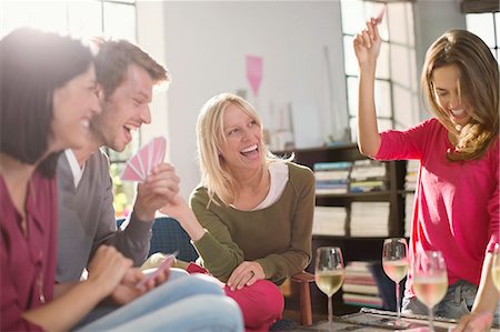 photo of card playing woman - Friends playing card games in living room Stock Photo - Premium Royalty-Free, Code: 6113-06625644