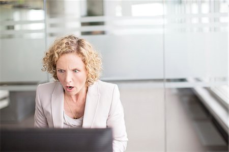 surprised - Surprised businesswoman working in office Stock Photo - Premium Royalty-Free, Code: 6113-06625697