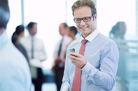 simsearch:6113-06753575,k - Businessman using cell phone in office Stock Photo - Premium Royalty-Free, Code: 6113-06625695