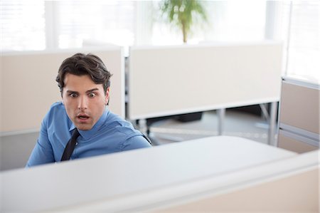 surprised young man - Surprised businessman working in office Stock Photo - Premium Royalty-Free, Code: 6113-06625696