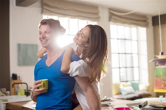 Smiling couple hugging in kitchen Stock Photo - Premium Royalty-Free, Image code: 6113-06625608