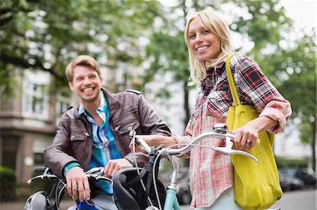 simsearch:6113-06625612,k - Couple standing on bicycles on city street Stock Photo - Premium Royalty-Free, Code: 6113-06625629