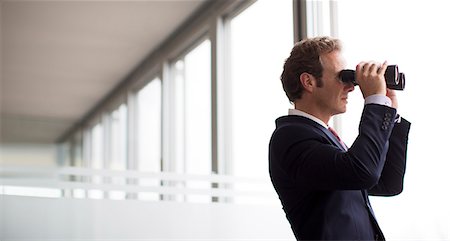 Businessman using binoculars at office window Photographie de stock - Premium Libres de Droits, Code: 6113-06625716