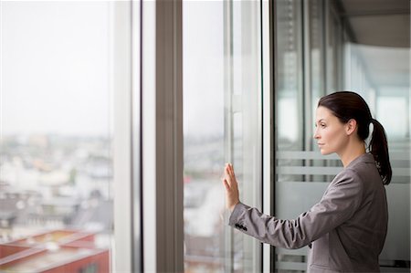 reflection and window - Businesswoman standing at office window Stock Photo - Premium Royalty-Free, Code: 6113-06625731