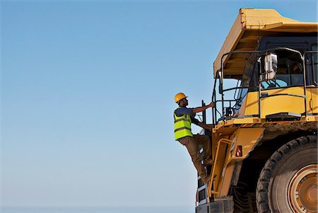 Worker climbing machinery on site Stock Photo - Premium Royalty-Free, Code: 6113-06625864