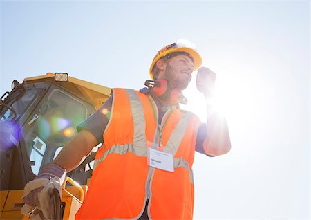 Worker using walkie-talkie on site Stock Photo - Premium Royalty-Free, Code: 6113-06625873