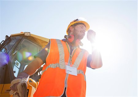 shout low angle - Worker using walkie-talkie on site Stock Photo - Premium Royalty-Free, Code: 6113-06625873