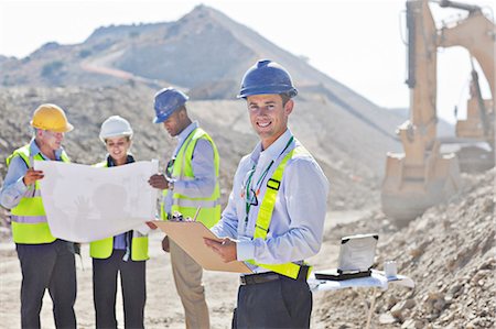 Businessmen reading blueprints in quarry Stock Photo - Premium Royalty-Free, Code: 6113-06625894