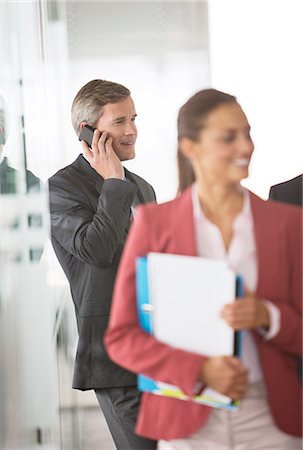 simsearch:695-05776257,k - Businessman talking on cell phone in office hallway Stock Photo - Premium Royalty-Free, Code: 6113-06625811