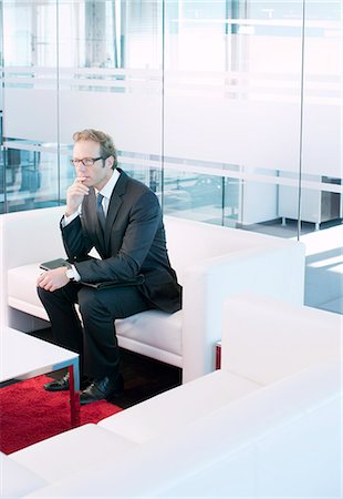 Business man sitting on sofa in office lobby Stock Photo - Premium Royalty-Free, Code: 6113-06625831