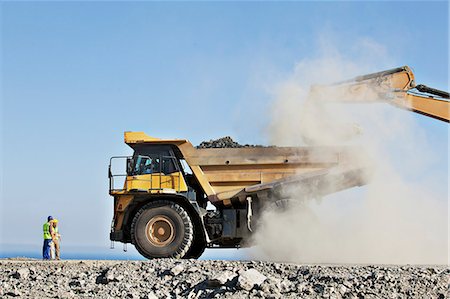 distancia (medición) - Workers overseeing digger and truck in quarry Foto de stock - Sin royalties Premium, Código: 6113-06625960