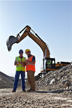 simsearch:6113-06625850,k - Workers talking by digger in quarry Photographie de stock - Premium Libres de Droits, Code: 6113-06625990