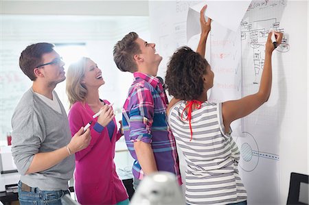 startup man woman from back - Business people reading blueprints in office Stock Photo - Premium Royalty-Free, Code: 6113-06625998