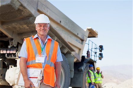 dump truck - Businessman standing by truck on site Foto de stock - Sin royalties Premium, Código: 6113-06625926