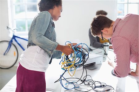 Business people untangling cords in office Foto de stock - Sin royalties Premium, Código: 6113-06626029