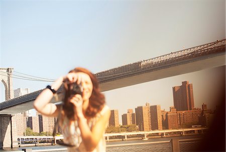 photographers taking photos of people - Woman taking pictures by urban bridge Stock Photo - Premium Royalty-Free, Code: 6113-06626145