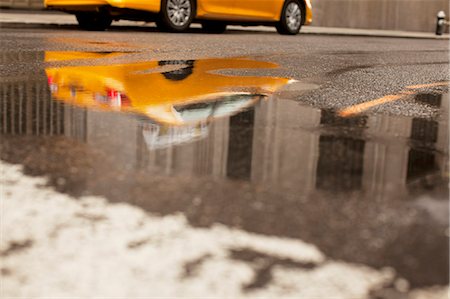 Taxi reflected in puddle on city street Foto de stock - Sin royalties Premium, Código: 6113-06626150