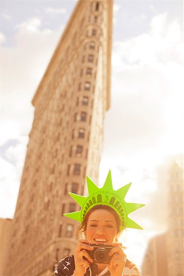 Woman in novelty hat taking picture on city street Photographie de stock - Premium Libres de Droits, Le code de l’image : 6113-06626182