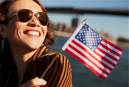 Woman waving American flag by urban bridge Stock Photo - Premium Royalty-Free, Code: 6113-06626190