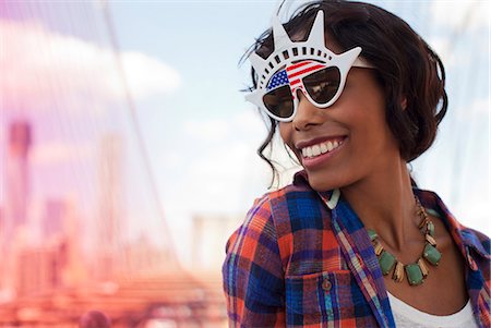 Woman wearing novelty sunglasses on city street Stock Photo - Premium Royalty-Free, Code: 6113-06626118