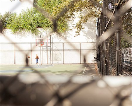 Man playing basketball on urban court Stock Photo - Premium Royalty-Free, Code: 6113-06626133