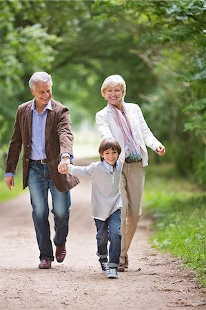 senior with grandchildren - Couple walking with grandson on rural road Stock Photo - Premium Royalty-Free, Code: 6113-06626296