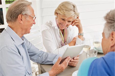 seniors socializing - Couple using digital tablet at table outdoors Photographie de stock - Premium Libres de Droits, Code: 6113-06626351