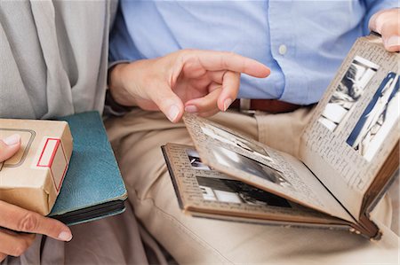 photograph print - Couple looking through photo album together Stock Photo - Premium Royalty-Free, Code: 6113-06626314