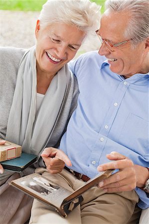 photograph print - Couple looking through photo album together Stock Photo - Premium Royalty-Free, Code: 6113-06626318