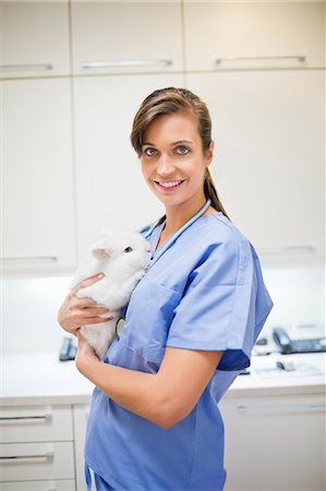 simsearch:6113-06626452,k - Smiling veterinarian holding rabbit in vet's surgery Foto de stock - Royalty Free Premium, Número: 6113-06626499