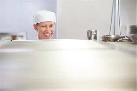 restaurant kitchen - Chef smiling in restaurant kitchen Stock Photo - Premium Royalty-Free, Code: 6113-06626551