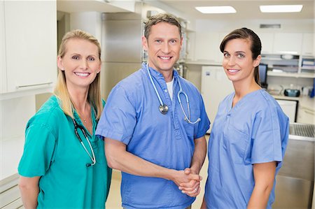 scrubs - Smiling veterinarians standing together in vet's surgery Stock Photo - Premium Royalty-Free, Code: 6113-06626501