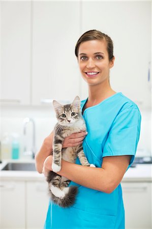 simsearch:6113-06626452,k - Smiling Veterinarian holding cat in vet's surgery Foto de stock - Royalty Free Premium, Número: 6113-06626515