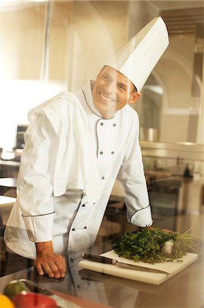 simsearch:6113-06626533,k - Chef smiling in restaurant kitchen Stock Photo - Premium Royalty-Free, Code: 6113-06626536