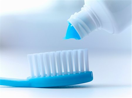 simsearch:6113-06626652,k - Close up of toothpaste squeezing on toothbrush Stock Photo - Premium Royalty-Free, Code: 6113-06626642