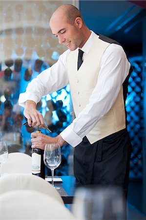 Waiter uncorking bottle of wine in restaurant Fotografie stock - Premium Royalty-Free, Codice: 6113-06626613