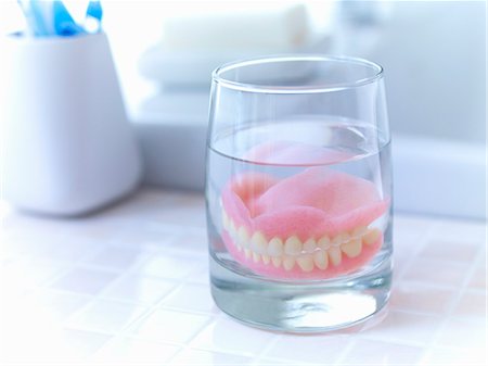 drenching - Close up of dentures soaking in glass of water Photographie de stock - Premium Libres de Droits, Code: 6113-06626633