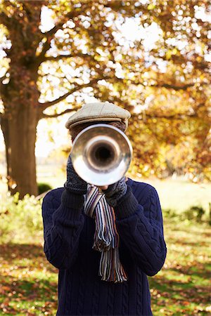 face covered with scarf - Teenage boy playing trumpet outdoors Stock Photo - Premium Royalty-Free, Code: 6113-06626738