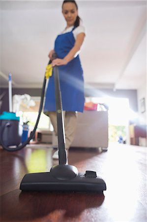 empregada doméstica - Woman vacuuming living room floor Foto de stock - Royalty Free Premium, Número: 6113-06753243