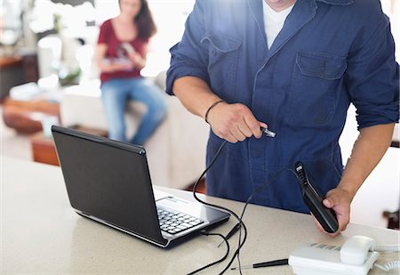 Electrician using laptop in home Stock Photo - Premium Royalty-Free, Code: 6113-06753248